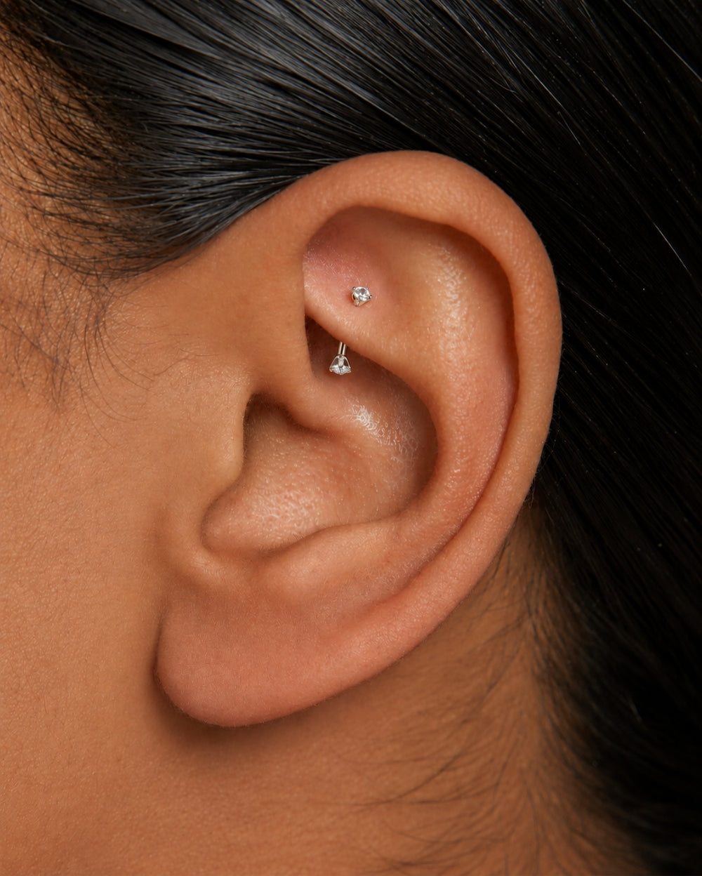 Model wearing White Gold curved barbell with diamonds on each end 