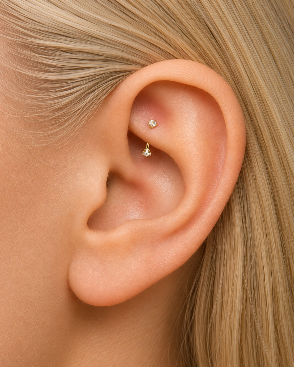 Model wearing Yellow Gold curved barbell with diamonds on each end on a white background