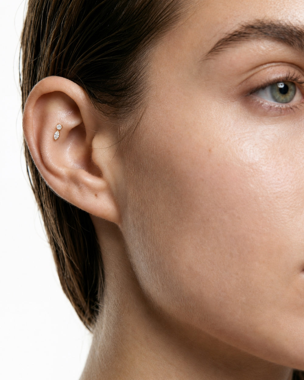 Model wearing a marquise and round diamond earring in a yellow gold claw setting and flatback post