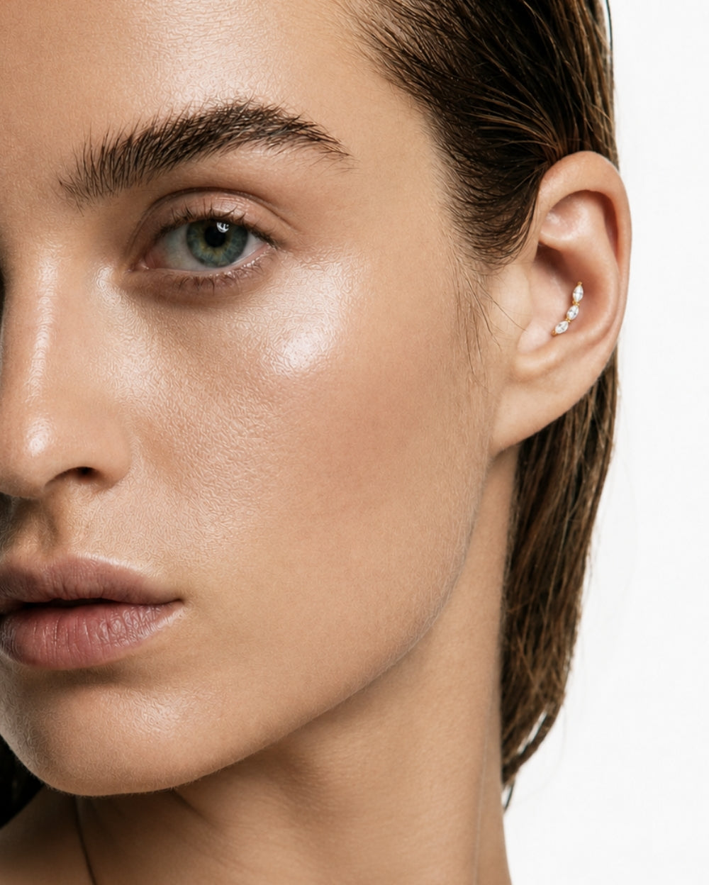 Model wearing marquise diamond trilogy earring set in yellow gold on a white studio background
